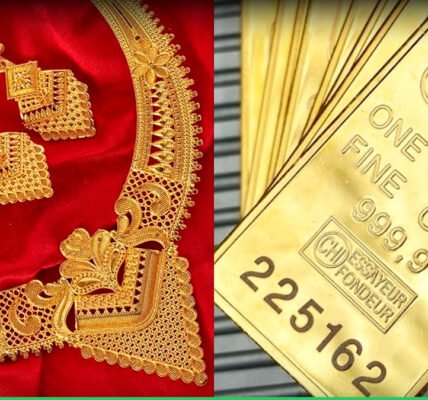 സ്വർണ്ണ നാണയങ്ങളും ആഭരണങ്ങളും ഒരു മേശപ്പുറത്ത് വെച്ചിരിക്കുന്നു, പശ്ചാത്തലത്തിൽ സ്റ്റോക്ക് മാർക്കറ്റ് ചാർട്ടുകൾ കാണാം.