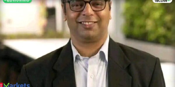 ഓഹരി വിപണിയിലെ ചലനങ്ങൾ സൂചിപ്പിക്കുന്ന ഗ്രാഫും അതിന് മുന്നിൽ ചിന്തിച്ചിരിക്കുന്ന നിക്ഷേപകനും