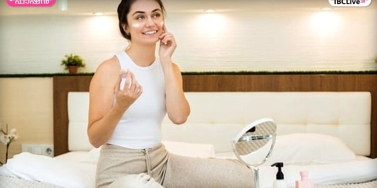 ഒരു യുവതി രാത്രികാല സ്കിൻകെയർ ഉൽപ്പന്നങ്ങൾ ഉപയോഗിച്ച് മുഖത്ത് പുരട്ടുന്നു
