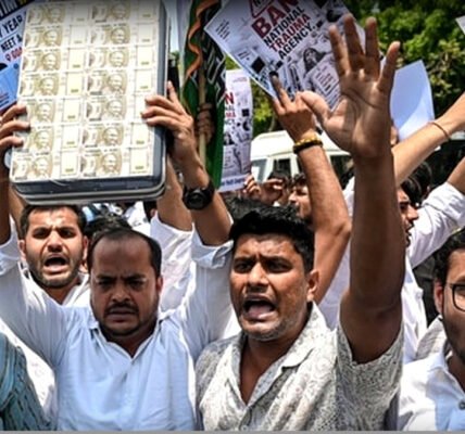 യൂത്ത് കോൺഗ്രസ് പ്രവർത്തകർ പ്രതിഷേധ പ്രകടനത്തിൽ 'ഇന്ത്യൻ യൂത്ത് കോക്രോച്ചസ്' എന്ന ബാനറുമായി നിൽക്കുന്നു.