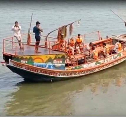 രക്ഷാപ്രവർത്തകർ ഗംഗാ നദിയിൽ കാണാതായവർക്കായി തിരച്ചിൽ നടത്തുന്നു, കരയിൽ ആളുകൾ തടിച്ചുകൂടിയിരിക്കുന്നു.