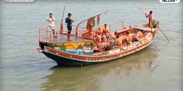 രക്ഷാപ്രവർത്തകർ ഗംഗാ നദിയിൽ കാണാതായവർക്കായി തിരച്ചിൽ നടത്തുന്നു, കരയിൽ ആളുകൾ തടിച്ചുകൂടിയിരിക്കുന്നു.