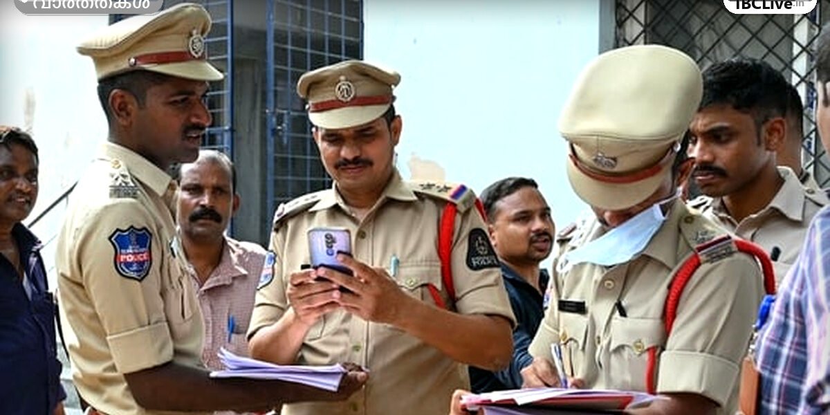രാത്രിയിൽ കത്തിയെരിയുന്ന ഒരു വാഹനത്തിന്റെ ചിത്രം, സമീപത്ത് പോലീസ് ഉദ്യോഗസ്ഥർ നിൽക്കുന്നു.