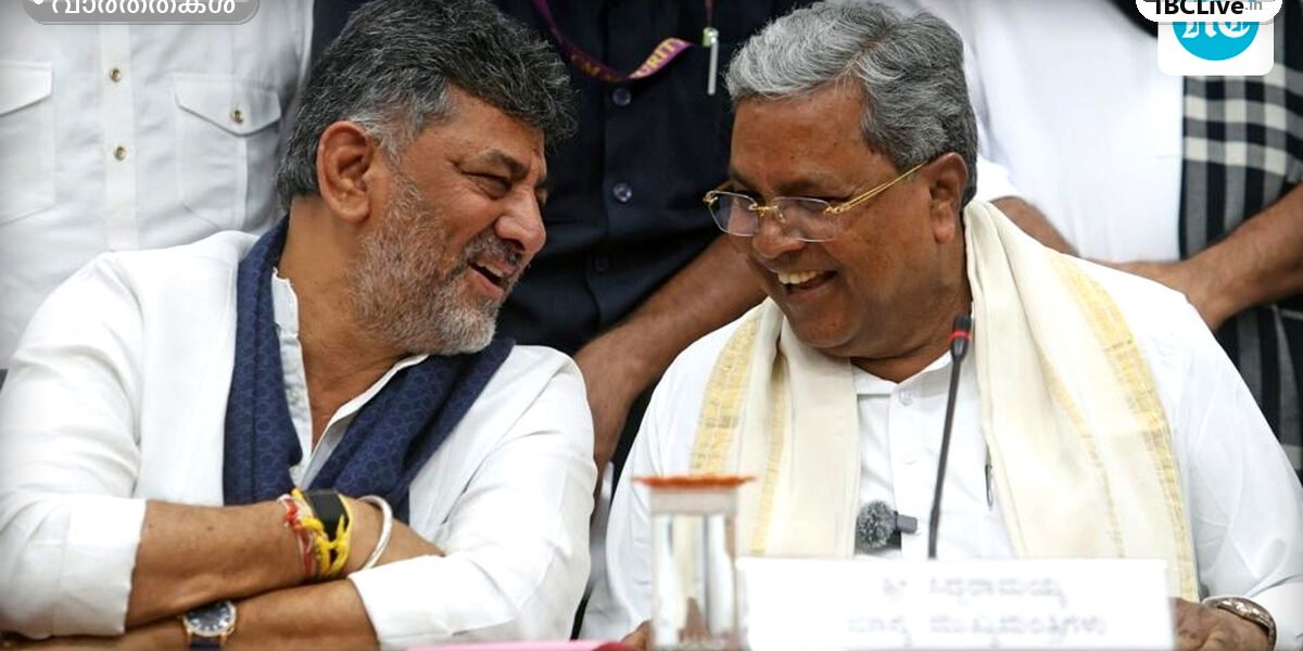കർണാടക മുഖ്യമന്ത്രി സിദ്ധരാമയ്യയും ഡികെ ശിവകുമാറും ഒരുമിച്ച് നിൽക്കുന്നു.